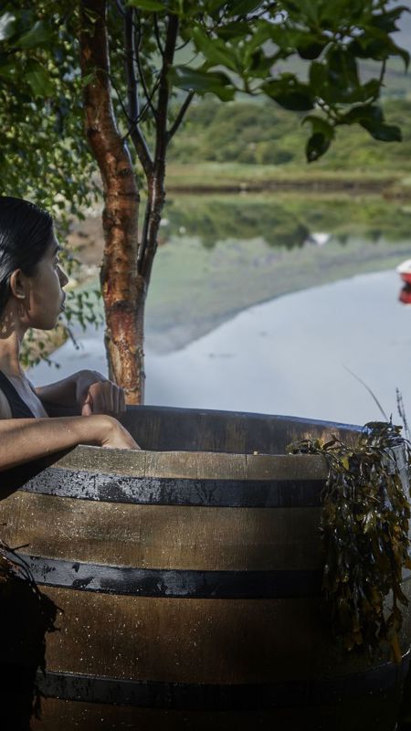 Lady sitting in the barrel overlooking bay